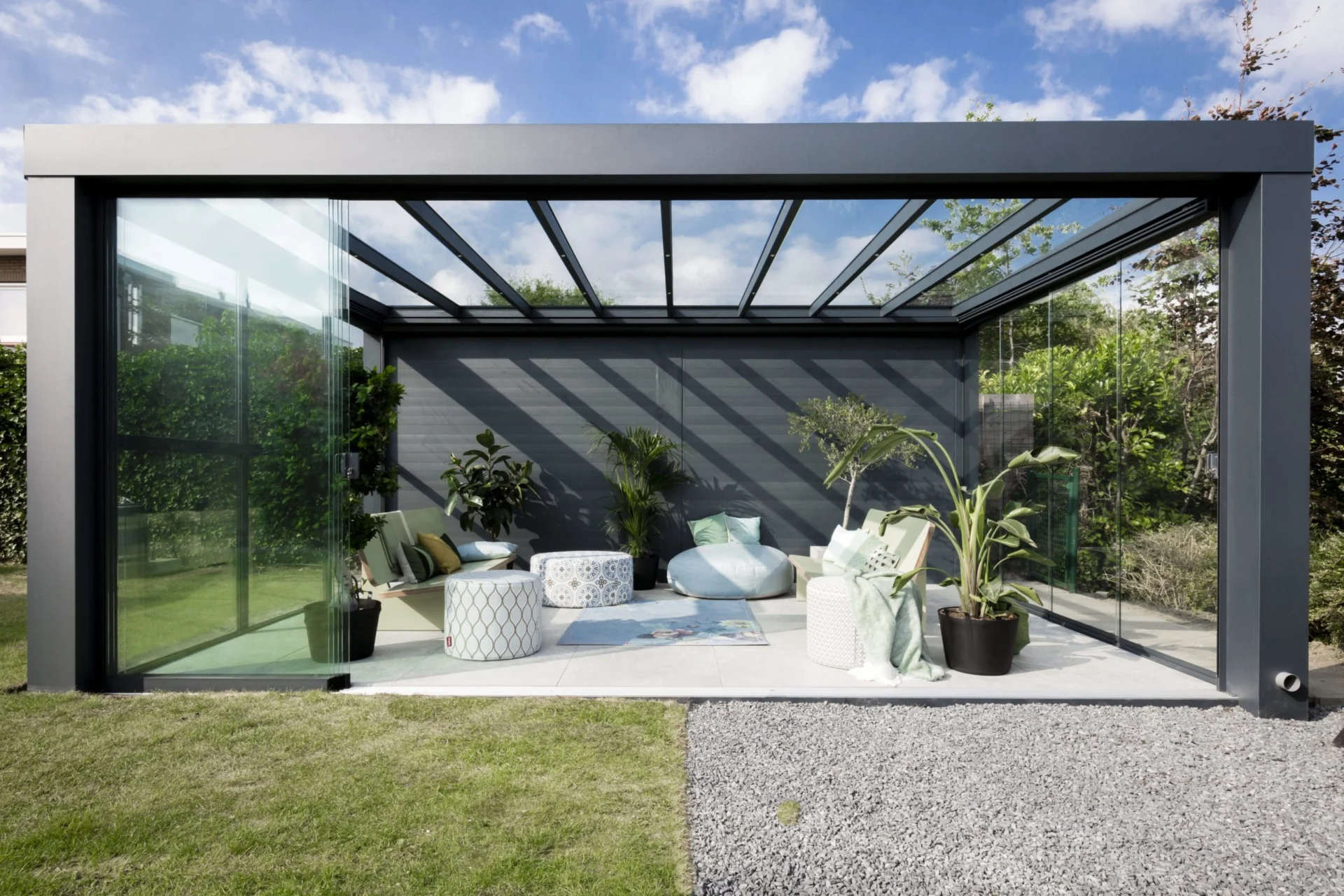 Tuinkamer Stijlvolle Verasol Cube tuinkamer met glazen schuifwanden en een aluminium frame in antraciet, ideaal als luxe buitenverblijf.