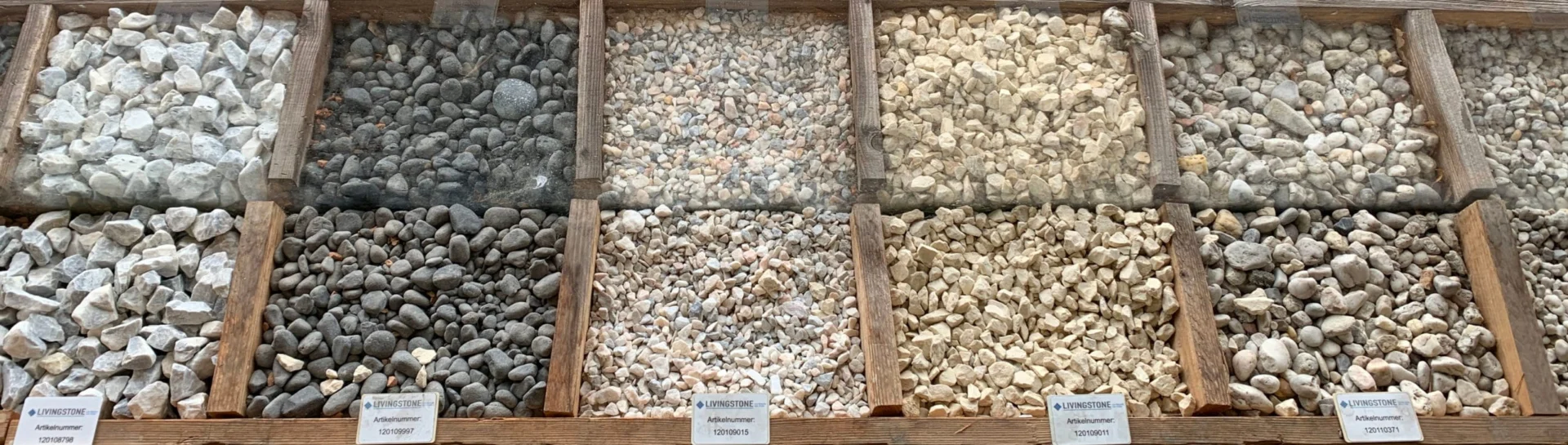 Grind en ondergronden Assortiment siergrind en split in verschillende kleuren en formaten, gepresenteerd in houten bakken bij Livingstone Goes.
